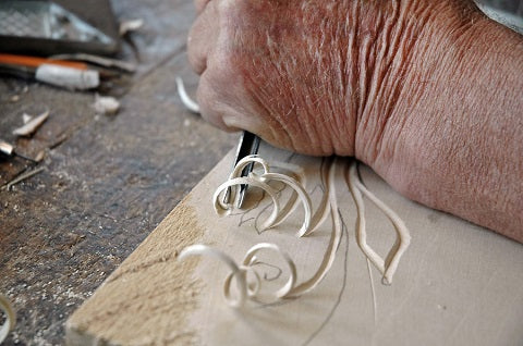 hand of an old craftsman carving a bas relief