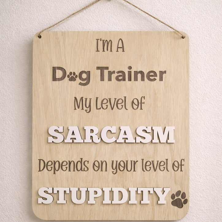 Wooden sign with humorous text about a dog trainer's sarcasm level.